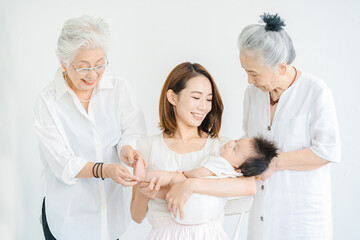 Obraz premium 赤ちゃんを抱っこするシニア女性とお母さん