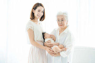 Obraz premium 赤ちゃんを抱っこするシニア女性とお母さん