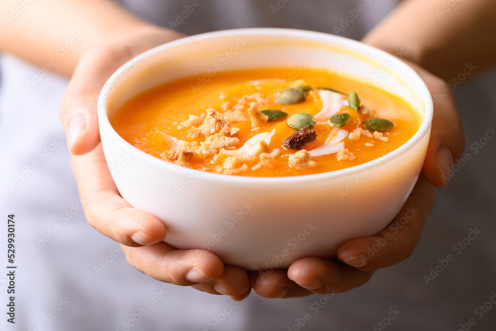 Canvas Prints butternut squash pumpkin soup in bowl holding by woman hand, homemade food in autumn season