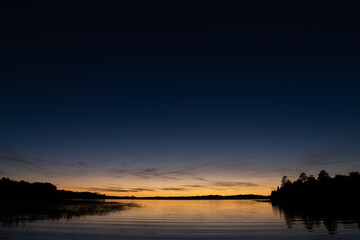 Fototapeta na wymiar Fading sunset glow at dusk over northern lake scene for magazine newsletter advertising layout design