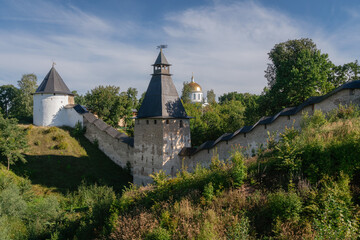 View of the wall of the Holy Dormition Pskov-Pechersk Monastery, the Tower of the Upper Lattices, Tailovskaya tower on a sunny summer day, Pechory, Pskov region, Russia - obrazy, fototapety, plakaty