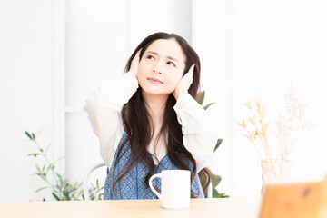 リビングで騒音に困っている女性
