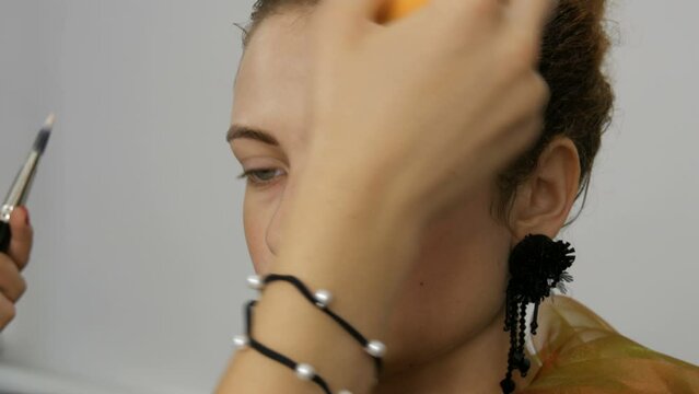 Preparing for evening makeup. A special sponge applies concealer on the face as a foundation for makeup