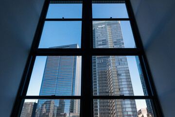 窓越しに見る高層ビル群、都市風景
