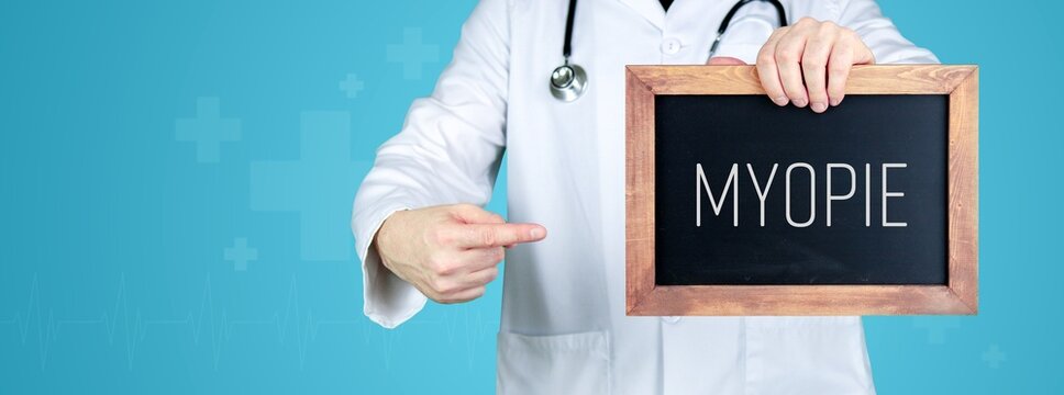 Myopie (Kurzsichtigkeit). Arzt zeigt medizinischen Begriff auf einem Schild/einer Tafel
