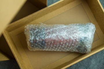 Fragile item wrapped in bubble wrap put in a brown box