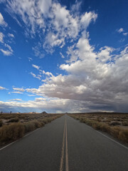 clouds flowing in different directions over a road in the Mojave Desert