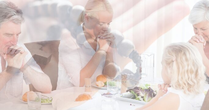 Multiple Exposure Of Caucasain Family Praying At Dinning Table And Hand With Rosary In Background