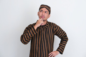 Asian man wearing traditional Javanese costume showing thinking expression