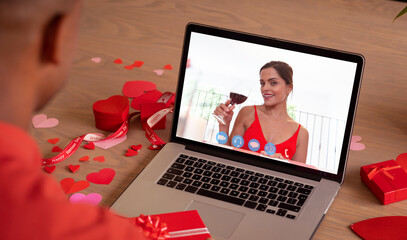 Caucasian young woman with red wine online dating with biracial boyfriend on valentine day - Powered by Adobe