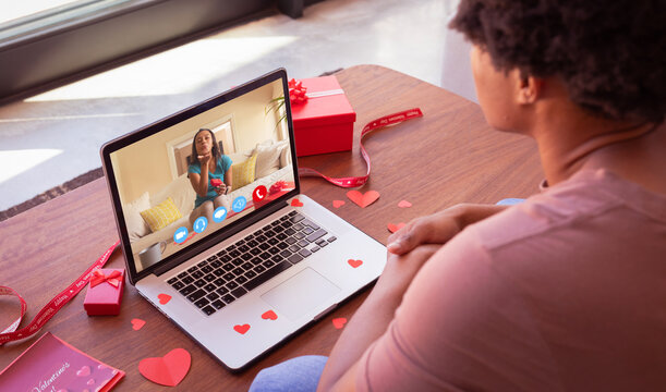 Biracial young woman blowing kiss to african american boyfriend while online dating