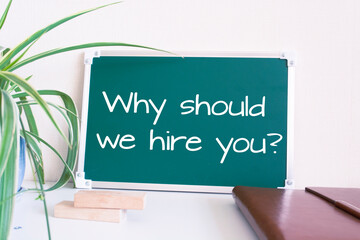 Text Why should we hire you? written on the green chalkboard