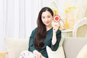 OKのプレートを見せる女性