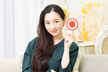 OKのプレートを見せる女性