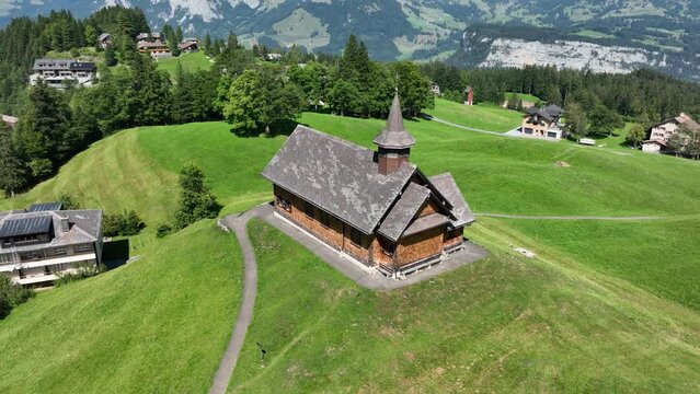 Fronalpstock Klingenstock wooden chapel in Stoos in central Switzerland a small wintersport ski resort village. Grassland alps alpine town on a clear sunny summer day. Clear mountain air and sky.