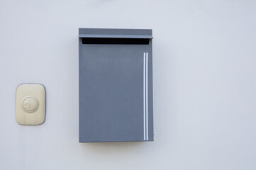 Mailboxes and front door bells are mounted on a white wall.