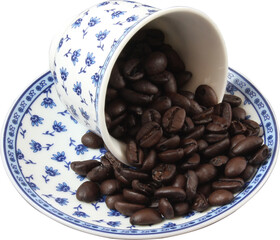 Dark coffee beans spilling from a Turkish coffee cup, isolated