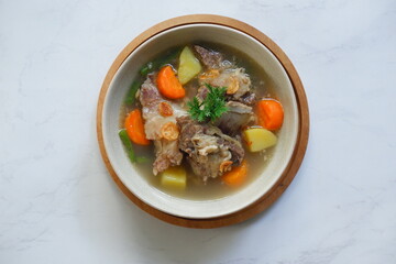 a bowl of beef ribs soup and vegetables