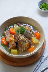 a bowl of beef ribs soup and vegetables