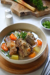 a bowl of beef ribs soup and vegetables