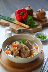 a bowl of beef ribs soup and vegetables