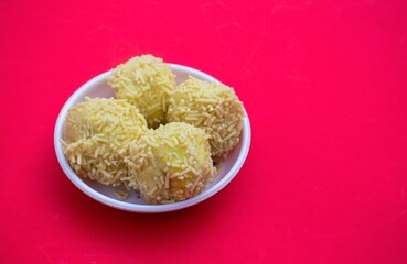 Closeup of Khoya Kheer Kadam or Raskadam in a White Plate Isolated on Red Background with Copy Space for Texts Writng