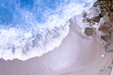 Fototapeta premium Aerial view waves crashing on sand of beach and soft wave background,Top view