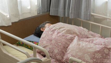 介護用ベッドで眠る高齢者女性（アップ）