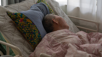 介護用ベッドで眠る高齢者男性（超アップ）