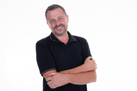 Portrait Of Caucasian Mature Middle-aged Man In Black Shirt Looking At Camera And Smiling Isolated In White Background