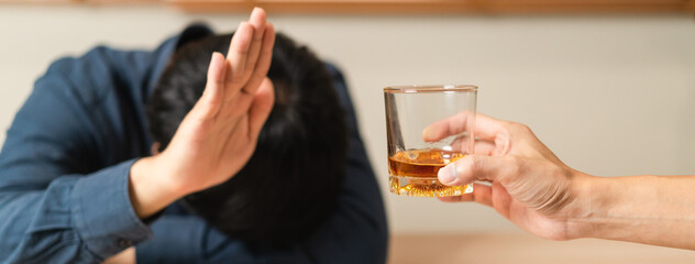 Alcoholism, sad depressed asian young man refuse, push alcoholic beverage glass, drink whiskey,...