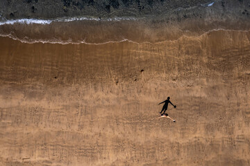 Aerial view tourist walking on a sand of Streedagh beach in county Sligo, Ireland. Beautiful nature scene with warm yellow sand and blue ocean. Popular tourist area. Warm sunny day.