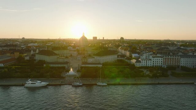 Slide and pan footage of waterfront, Amalienborg palace, royal residence and famous Frederiks Kirke against sunset. Copenhagen, Denmark