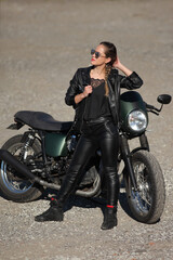 Plakat Portrait of young woman on a black motorcycle