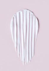 close-up cosmetic smear cream texture on pastel pink background	
