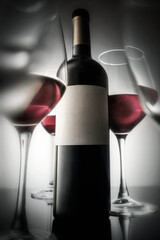 Glasses of red wine and a bottle of red wine with a white label. Still life vertical photography mockup copyspace