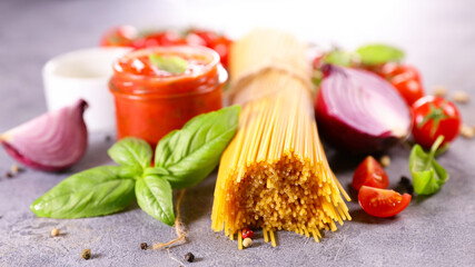 raw spaghetti composition with tomato, basil and spice