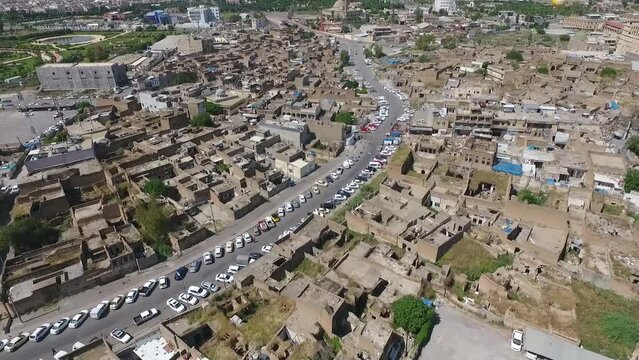 An aerial shot of the city of Erbil showing the ancient Erbil Citadel and the garden opposite the castle with water fountains and the popular market