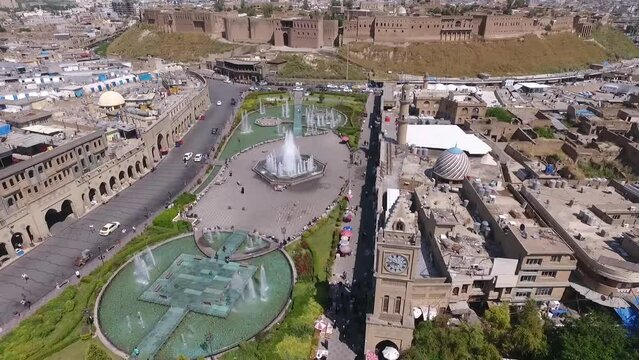 An aerial shot of the city of Erbil showing the ancient Erbil Citadel and the garden opposite the castle with water fountains and the popular market