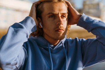 Obraz premium Young blonde man listening music while working out on sunrise