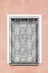 Rose wall with window on a wall with grey jalousie and white bars in the front, space for text