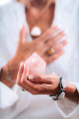 Self-esteem concept. Hand holding a rose quartz crystal, boosting feeling of self-esteem and self-love, improving mood and harmony - obrazy, fototapety, plakaty