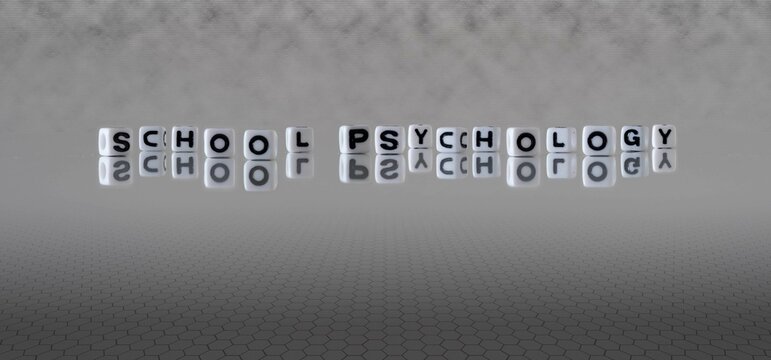 school psychology word or concept represented by black and white letter cubes on a grey horizon background stretching to infinity