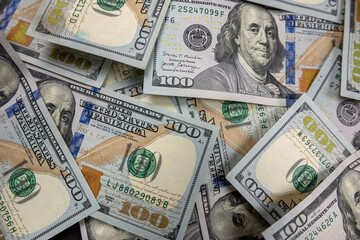 close-up stacks of hundred dollar bills isolated on dark background.