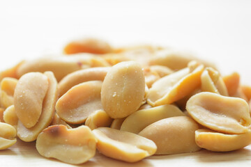 Salted Peanuts on natural light background. Front view close up.