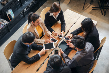Creative Team, working together with smartphone at office desk. Professional business team meeting, discussion and research together start up project strategy. Group of colleagues plan to work online.