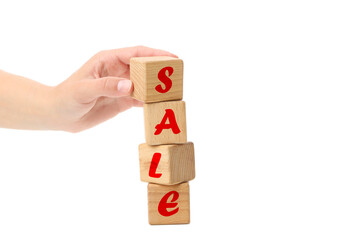 Wooden cubes with text Sale and female hand isolated on white background