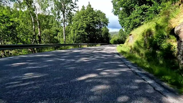 First person view of a nordic road, Norway, lush green contryside
