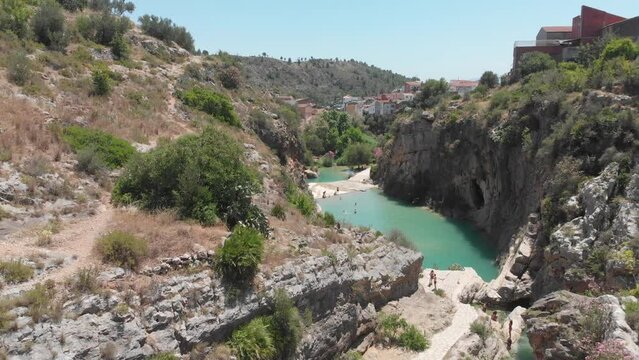 Natural pools and village of Bolbaite, Spain on cliffs overlooking river. Dolly right.