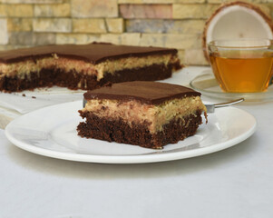 Bounty Cake on white plate with a spoon and caramel sauce